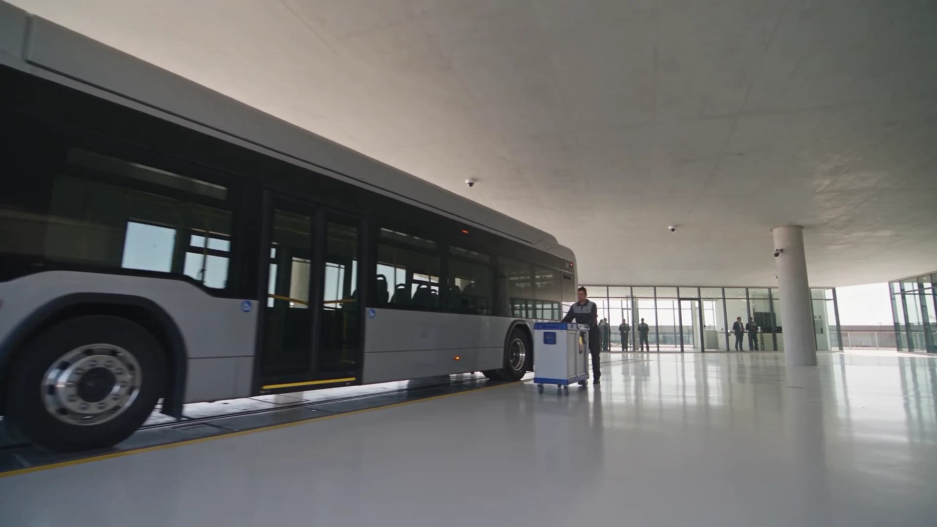 Bright electric-bus depot where an established camera estate supports an operating crew